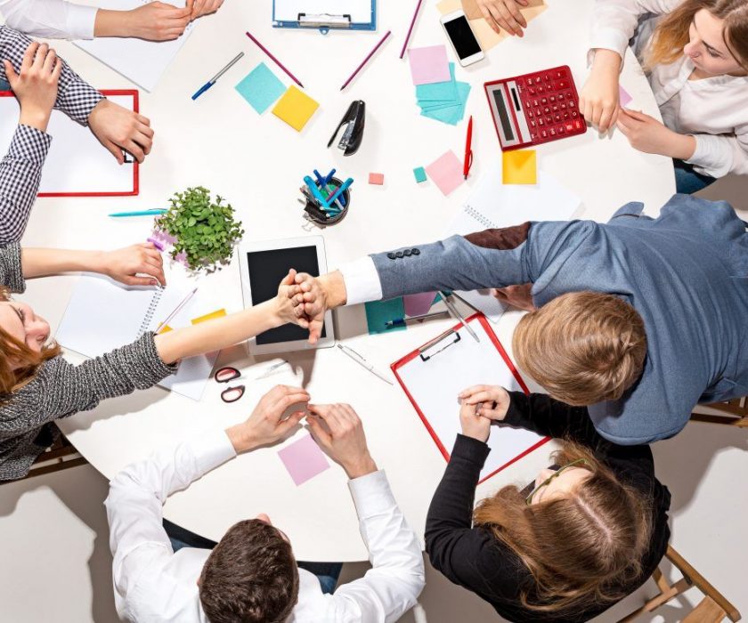 team-sitting-behind-desk-checking-reports-talking-top-view-the-business-concept-of-collaboration-team-work-meeting-1024×765